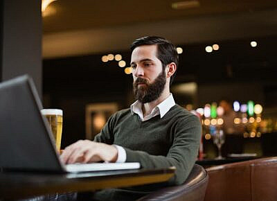 A bookie reviewing sportsbook earnings on a laptop.