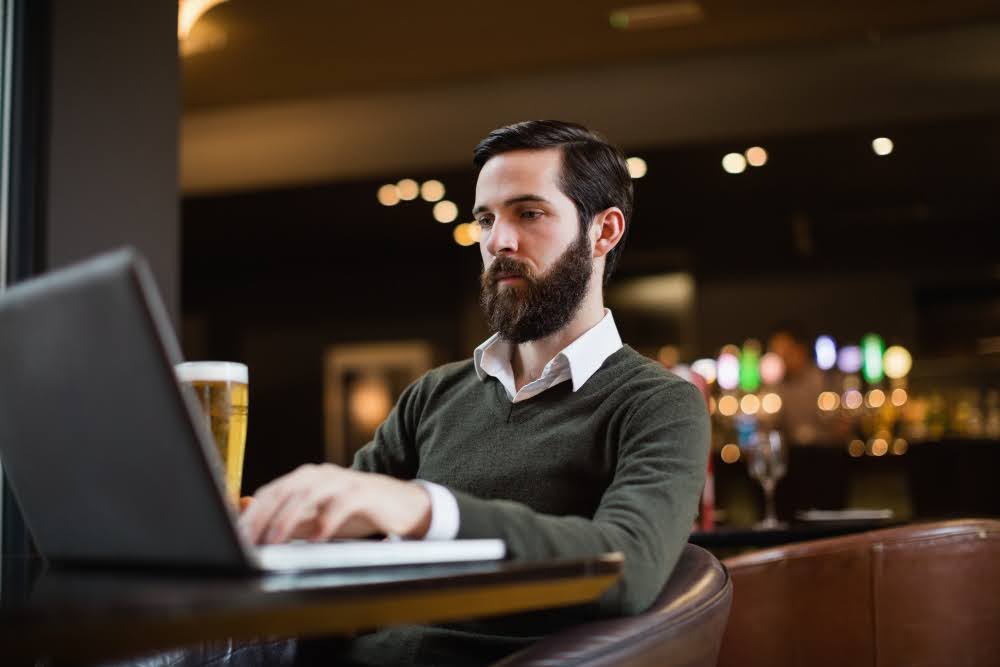 A bookie reviewing sportsbook earnings on a laptop.