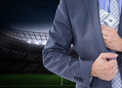 A close-up of a person putting cash into their pocket after a successful sportsbook withdrawal.