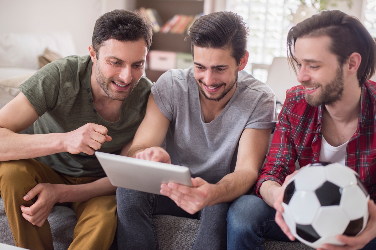 Men watching a football game and betting online. 